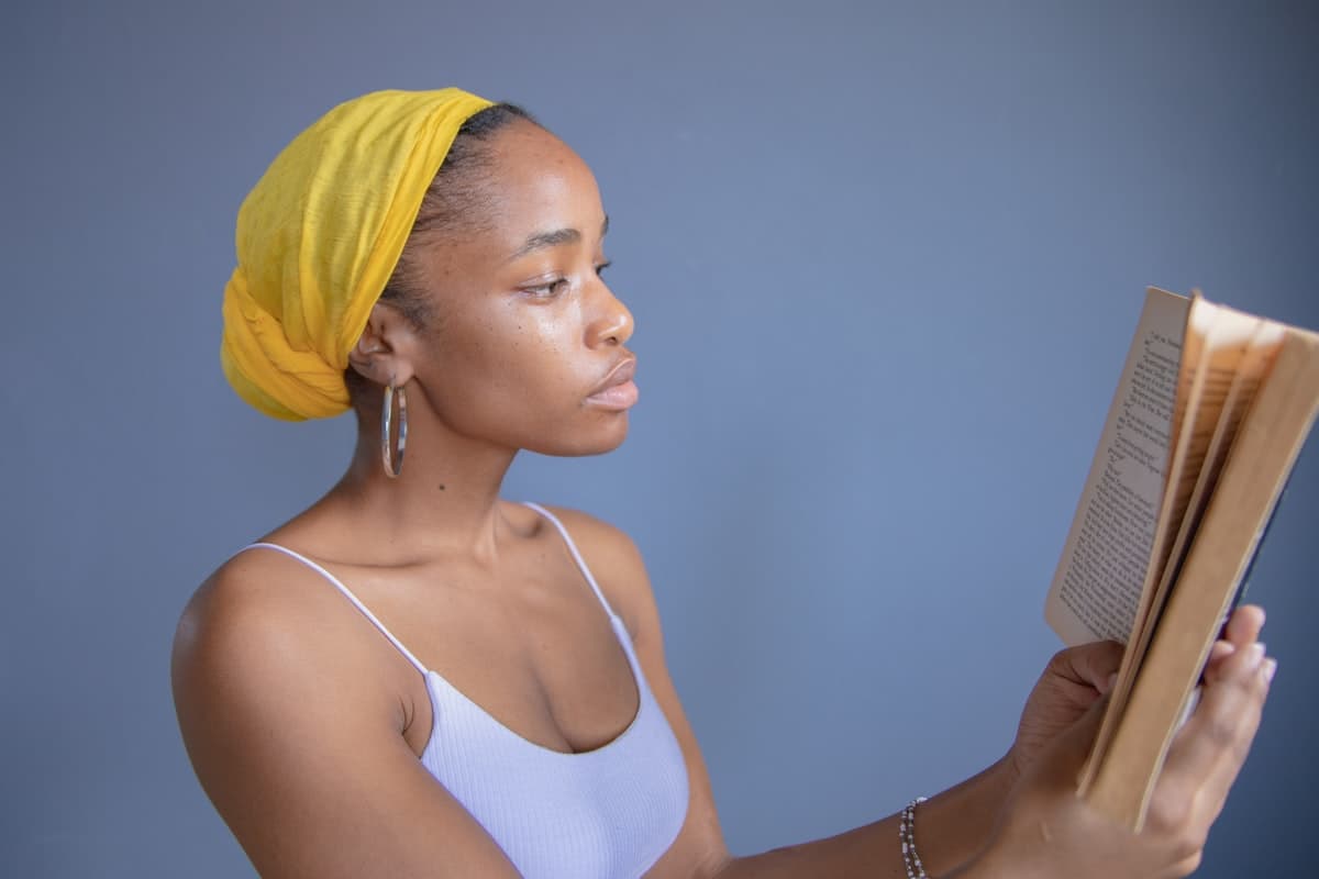 Woman in yellow hijab reading calmly — clarity and guidance