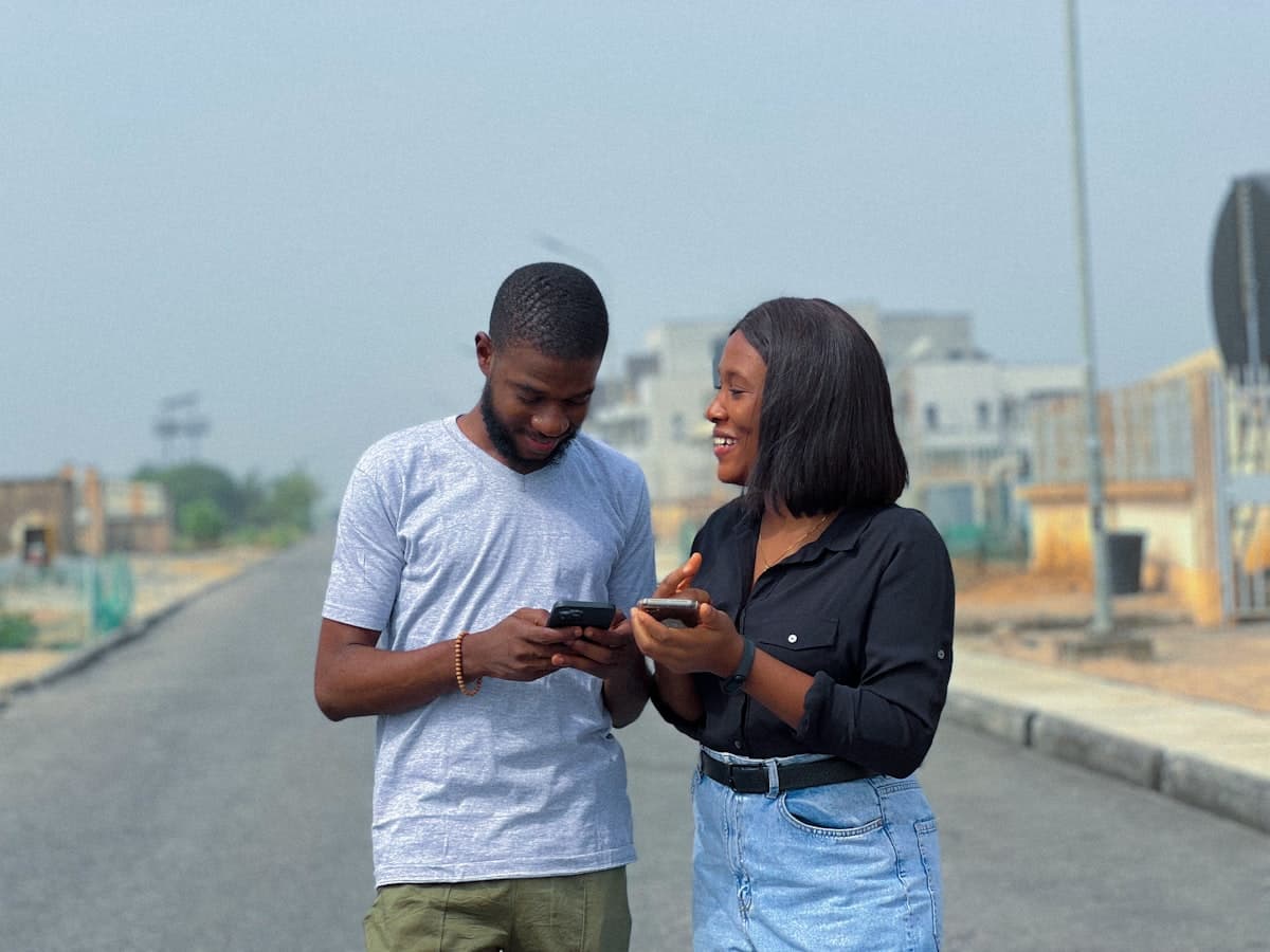 Two people looking at phone together — coordinating and keeping everybody on same page